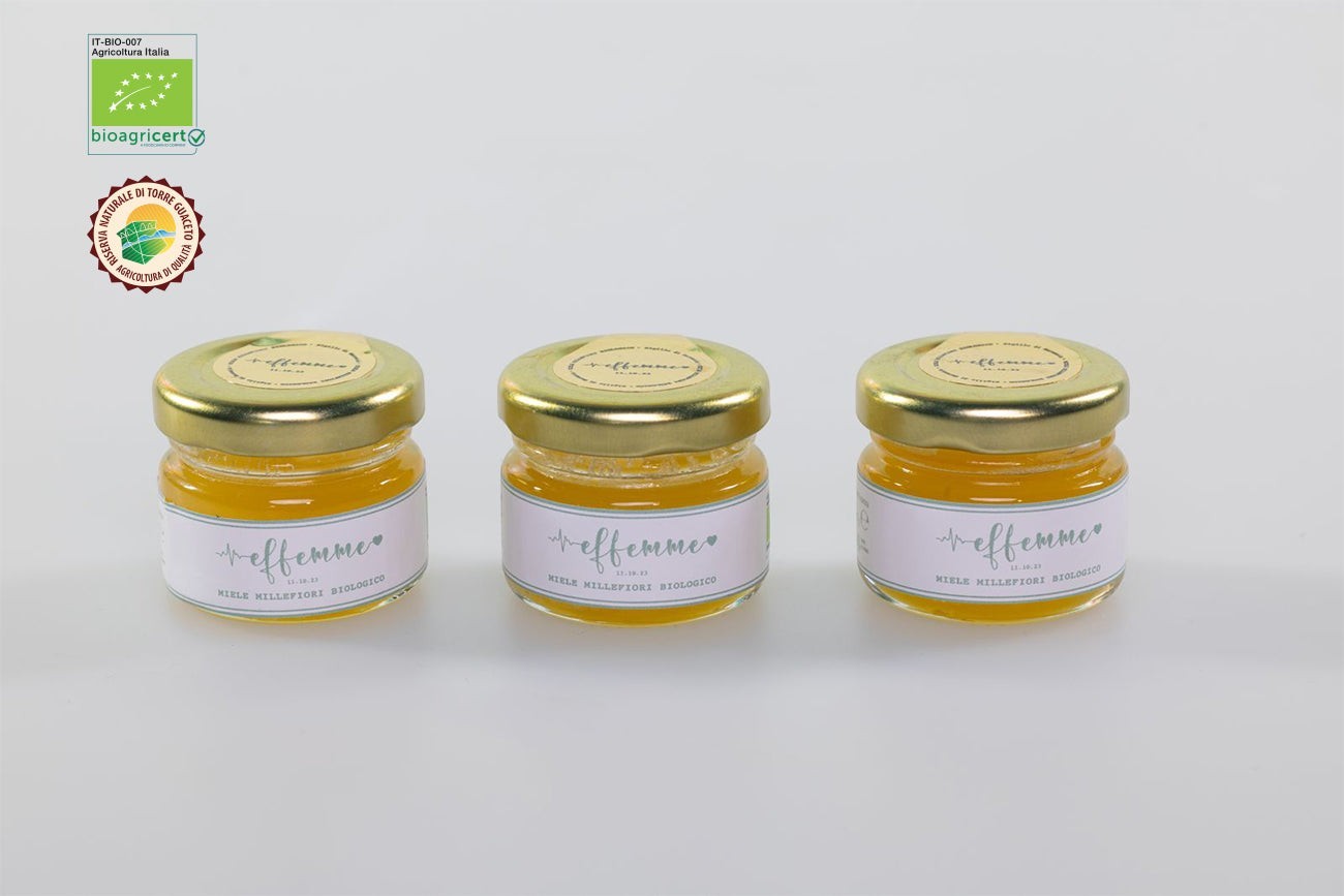 Tre vasetti di miele millefiori biologico Agricolasifè con etichette personalizzate, ideali come bomboniere eleganti.